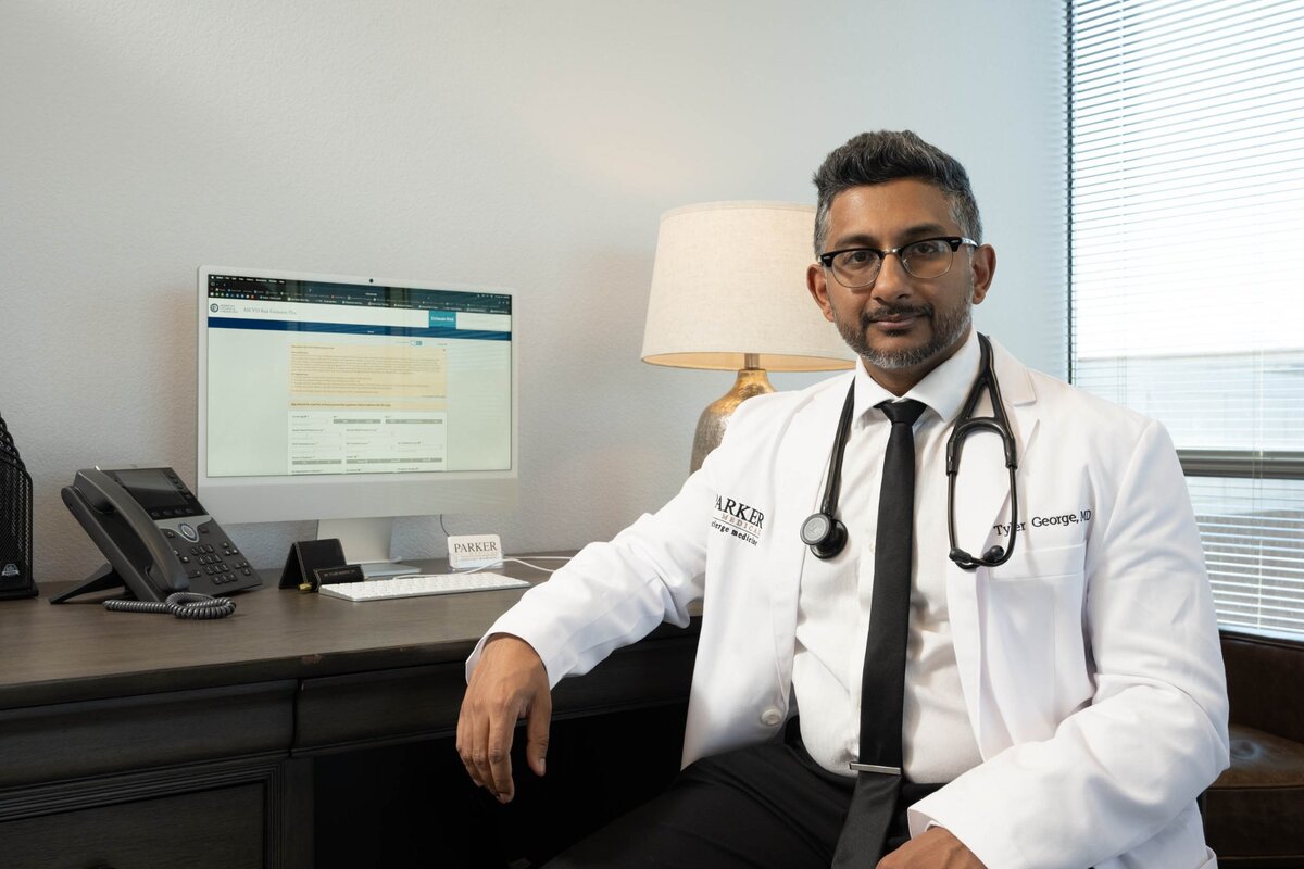 Dr. Tyler George MD at his desk reviewing men's health lab results at Parker Medical Las Vegas