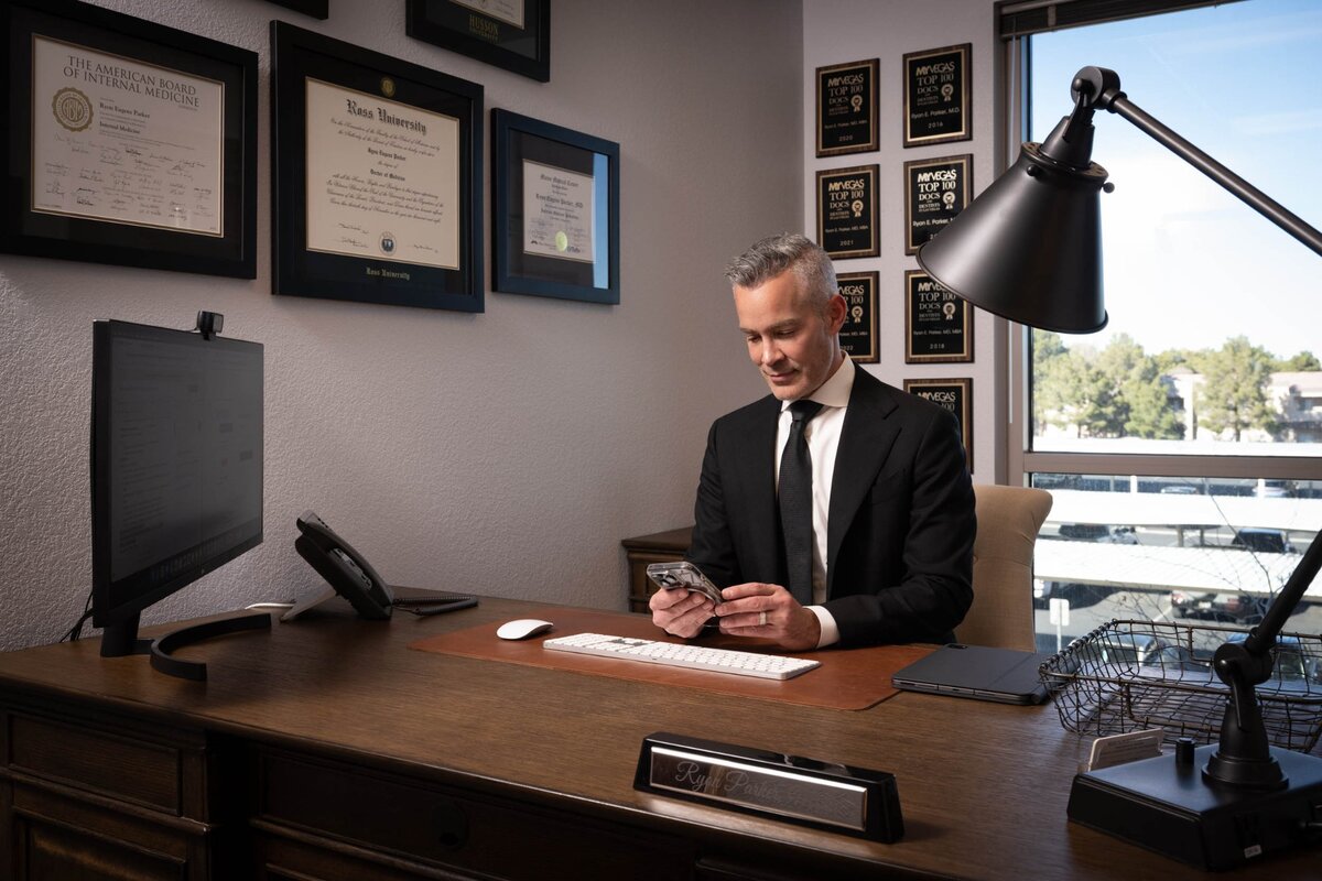 Dr. Ryon Parker MD MBA responding to patient messages at his desk at Parker Medical Las Vegas
