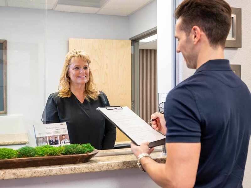 Friendly staff greeting patient at front desk